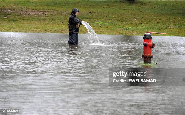 Man uses a pump as rain waters flooded a street in Oak Bluffs on Martha's Vineyard, Massachusetts, on August 29, 2009. Tropical Storm Danny...