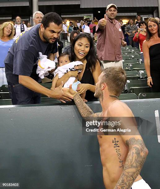 David Beckham of the Los Angeles Galaxy gives his jersey to a young family after his MLS match against Chivas USA on August 29, 2009 at the Home...