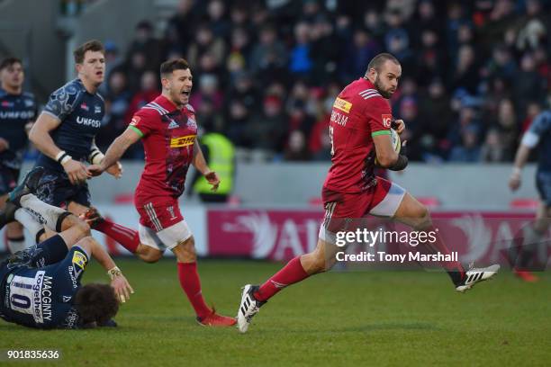 Ross Chisholm of Harlequins breaks through a tackle by AJ MacGinty of Sale Sharks to score a try during the Aviva Premiership match between Sale...