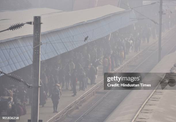 Passengers waiting for their trains at Old Delhi Railway station during a cold and foggy weather, on January 06, 2018 in New Delhi Area, India. As...