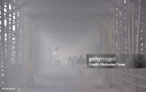 Commuters brave through a thick layer of fog, on January 06, 2018 in New Delhi Area, India. As per met department, the foggy weather did bring the...