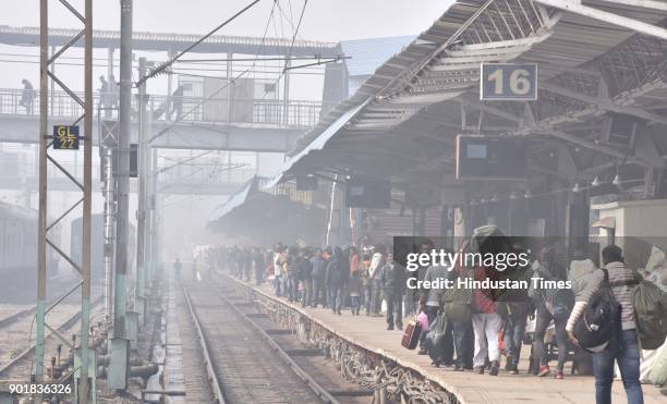 Passengers waiting for their trains at Old Delhi Railway station during a cold and foggy weather, on January 06, 2018 in New Delhi Area, India. As...