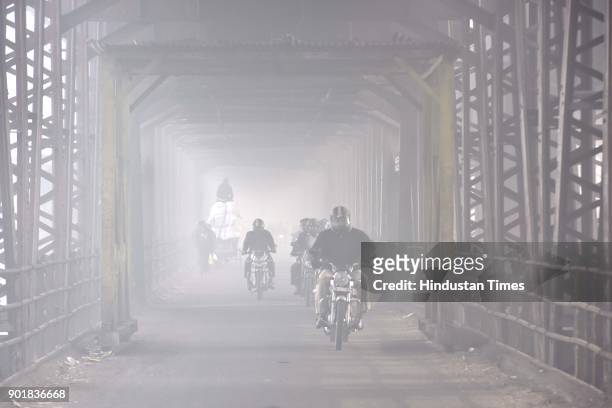 Commuters brave through a thick layer of fog, on January 06, 2018 in New Delhi Area, India. As per met department, the foggy weather did bring the...