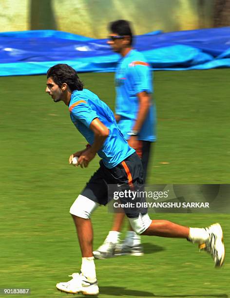 Indian cricketer Ishant Sharma runs to deliver the ball at the nets as team bowling coach Venkatesh Prasad looks on during a training session at...