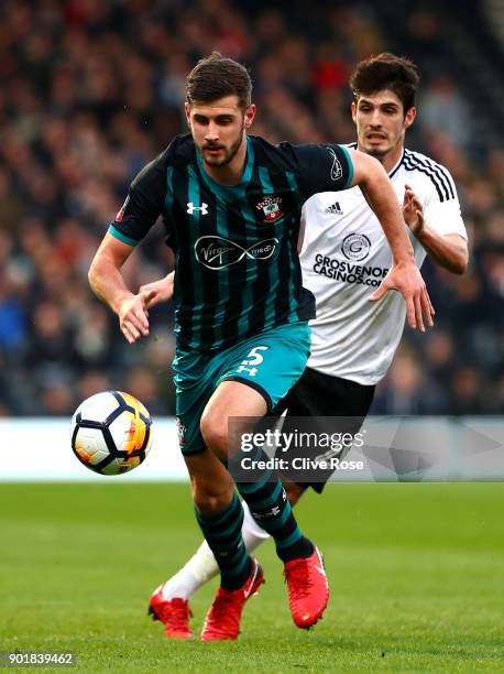 Jack Stephens of Southampton runs with the ball under pressure from Lucas Piazon of Fulham during The Emirates FA Cup Third Round match between...