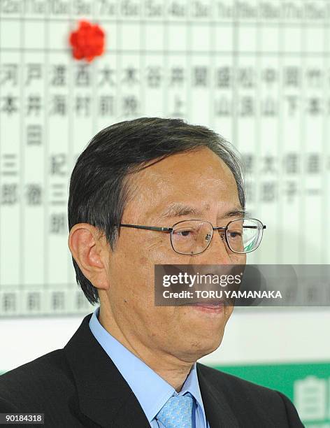 Hiroyuki Hosoda, secretary general of the ruling Liberal Democratic Party watches up-to-the-minute returns in front of a board showing candidate...