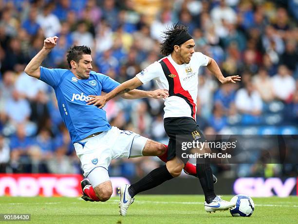 Richard Hughes of Portsmouth tackles Carlos Tevez of Manchester City during the Barclays Premier League match between Portsmouth and Manchester City...