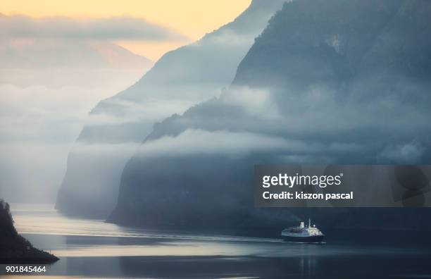 fjord in norway with ferry boat during a foggy morning , scandinavia - fjord stock-fotos und bilder