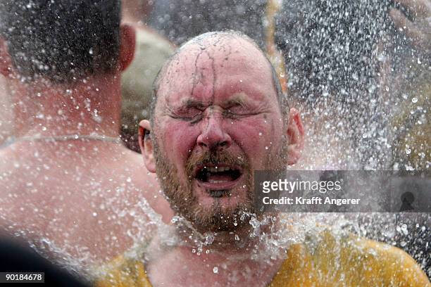 Participants shower after the football matches during the Mudflat Olympic Games on August 30, 2009 in Brunsbuttel, Germany.