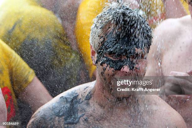 Participants shower after the football matches during the Mudflat Olympic Games on August 30, 2009 in Brunsbuttel, Germany.