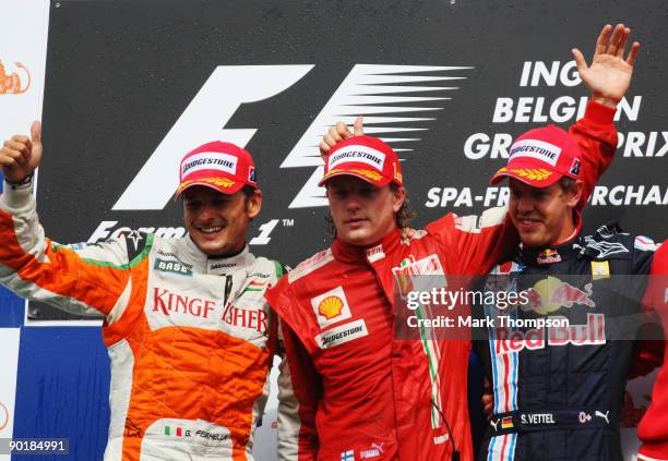 Race winner Kimi Raikkonen of Finland and Ferrari celebrates on the podium with second placed Giancarlo Fisichella of Italy and Force India and third...