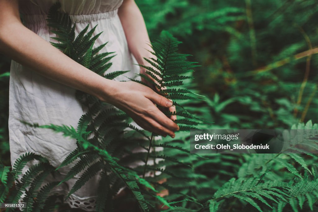 Frau in weißem Kleid im Wald spazieren
