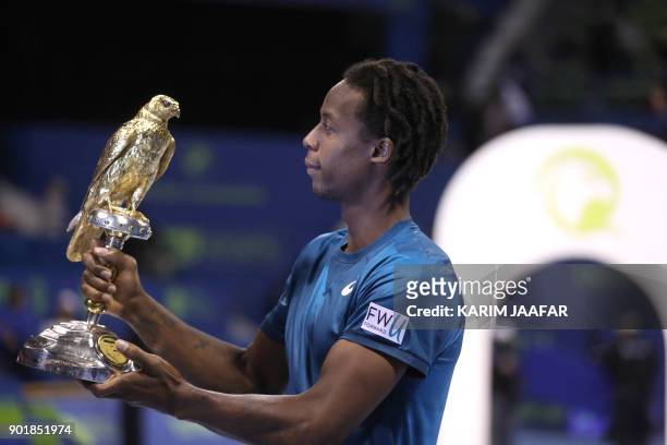 Gael Monfils of France holds the winner's trophy after winning against Russia's Andrey Rublev in the ATP Qatar Open tennis competition in Doha on...