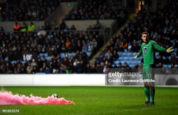 Liam O'Brien of Coventry City reacts to a smoke flare during The Emirates FA Cup Third Round match between Coventry City and Stoke City at Ricoh...