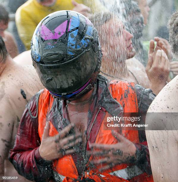 Participants shower after the football matches during the Mudflat Olympic Games on August 30, 2009 in Brunsbuttel, Germany.