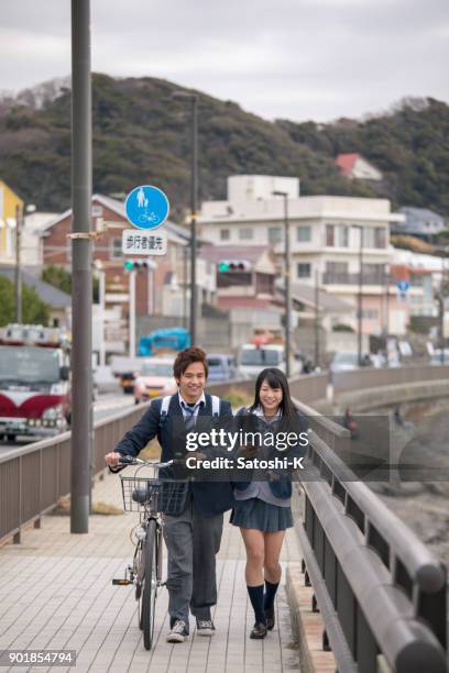 couple étudiant du secondaire vont à l’école ensemble - jeune fille asiatique bord de mer photos et images de collection