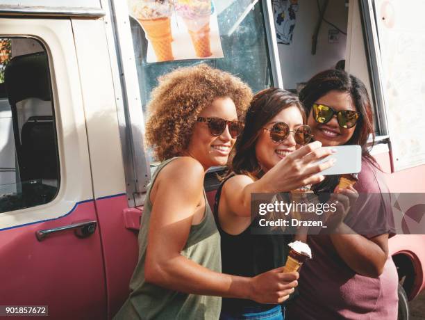 drei mädchen essen eis in der nähe von den eiswagen in australien - freundinnen urlaub sommer eis stock-fotos und bilder