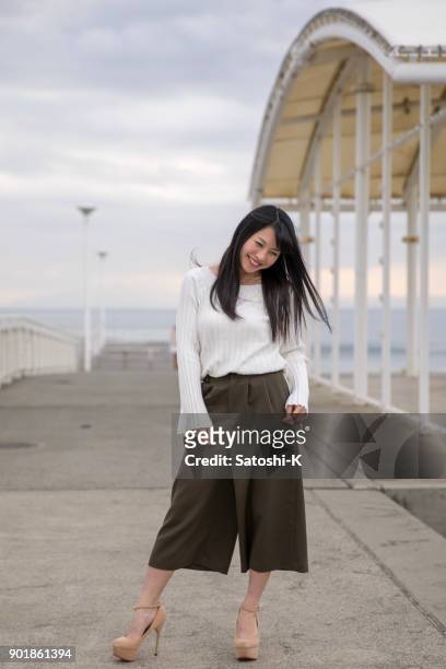 ビーチに立っている高校の女の子の肖像画 - 若い カワイイ 女の子 日本人 ストックフォトと画像