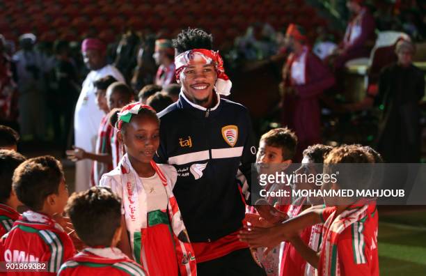 Omani football player Jameel Saleem al-Yahmadi walks among children during a celebration ceremony to welcome Oman's national football team after they...