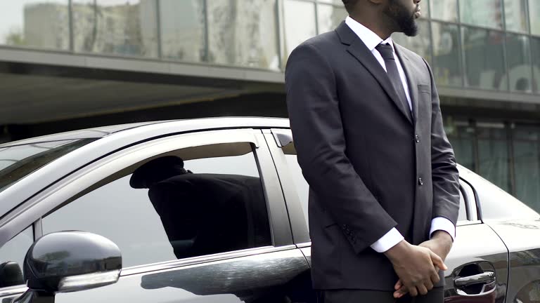 https://media.gettyimages.com/id/901871250/video/private-driver-and-bodyguard-standing-near-car-waiting-for-rich-vip-client.jpg?b=1&s=640x640&k=20&c=50zRf45luMf6DRuqyQzJ5xOeHbfAN2ERJiSRVZ0QjJc=