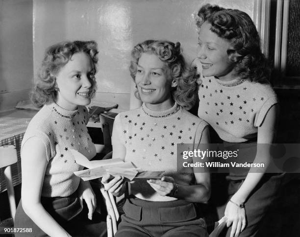 British vocal group the Beverley Sisters read congratulatory telegrams after being chosen to take part in the Royal Variety Performance at the London...