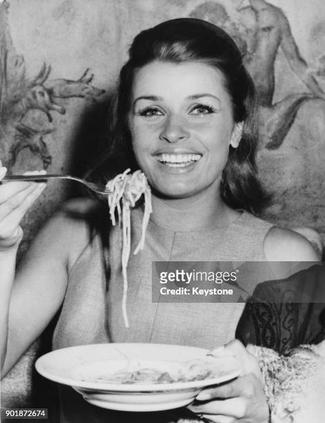 Austrian actress Senta Berger eating spaghetti in the Cinecitta Studios in Rome, Italy, during the filming of 'Operazione San Gennaro' , September...