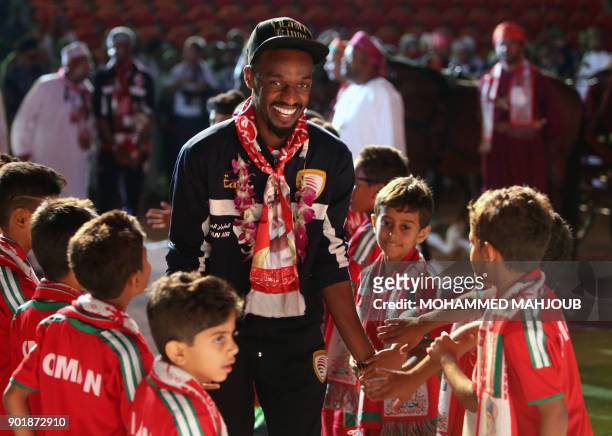 Omani football player Mohsin al-Khaldi walks among children during a celebration ceremony to welcome Oman's national football team after they won the...
