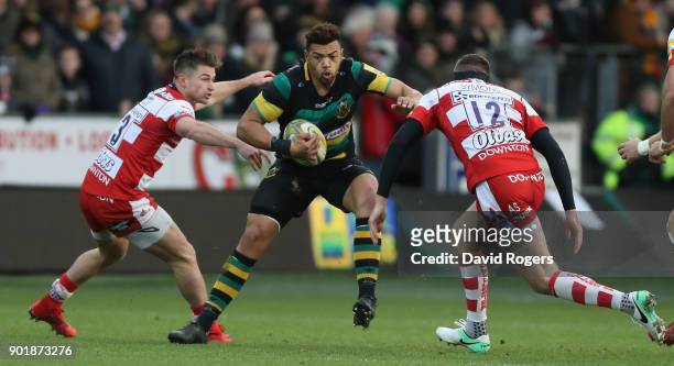 Luther Burrell of Northampton takes on Henry Trinder and Andy Symons during the Aviva Premiership match between Northampton Saints and Gloucester...