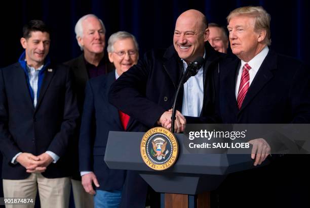 President Donald Trump shakes hands with Gary Cohn, Director of the National Economic Council, during a retreat with Republican lawmakers and members...