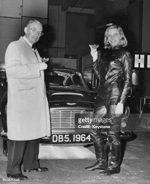 English actress Honor Blackman of TV's 'The Avengers' and Aston Martin chairman David Brown with the new Aston Martin DB5 hard top at the Motor Show...