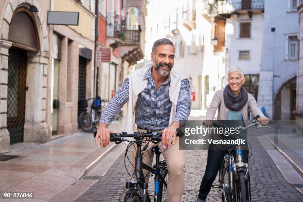 stadt mit dem fahrrad zu erkunden - old couple on holiday stock-fotos und bilder