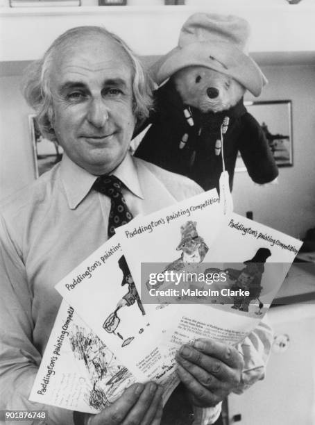 British writer Michael Bond , author of the Paddington Bear books, holds the four winning paintings in Paddington's Painting Competition at his...