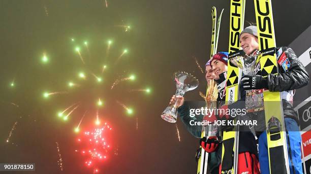 Anders Fannemel of Norway, Kamil Stoch of Poland and Andreas Wellinger of Germany celebrate on the podium after the fourth and final stage of the...