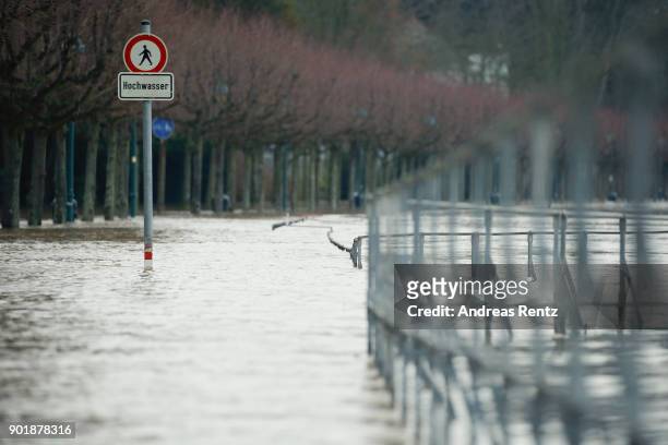Sign that reads 'Acces denied - High Tide' stands on flooded path near Rheinaue parc on January 6, 2018 in Bonn, Germany. The rain-swollen river...