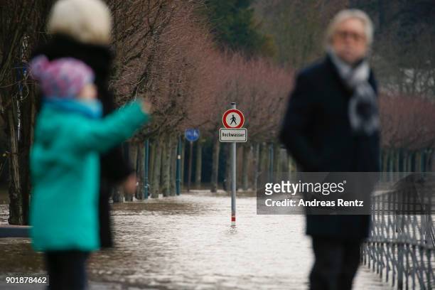 Sign that reads 'Acces denied - High Tide' stands on flooded path near Rheinaue parc on January 6, 2018 in Bonn, Germany. The rain-swollen river...