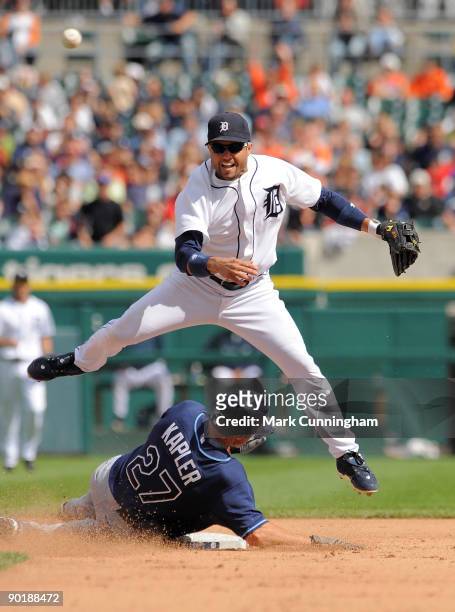 Placido Polanco of the Detroit Tigers throws to first base while leaping over a sliding Gabe Kapler of the Tampa Bay Rays during the game at Comerica...