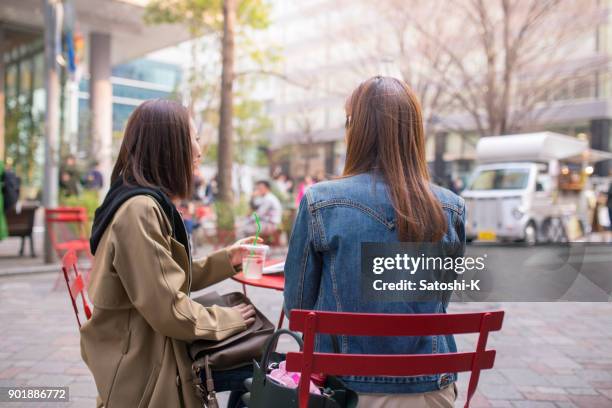 太陽の下でティータイムを持つ女性の友人 - cafe table chair outside ストックフォトと画像