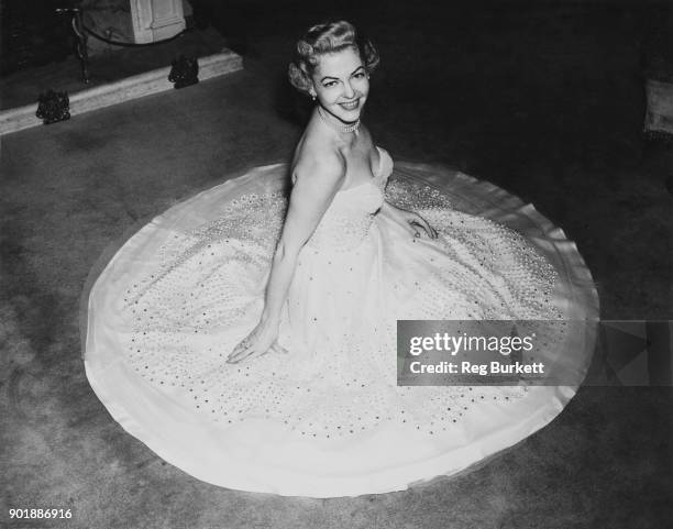 American actress and singer Vivian Blaine , star of the musical 'Guys and Dolls', tries on her dress for the Royal Command Performance at the London...