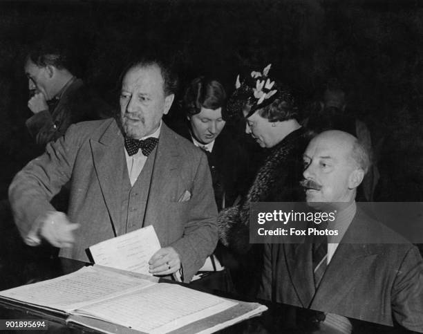 English conductors Sir Adrian Boult and Sir Henry Wood discuss the score for that evening's BBC Promenade Concert, during rehearsals at the Royal...