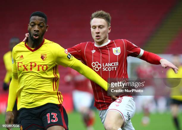 Watford's Molla Wague and Bristol City's Cauley Woodrow during FA Cup 3rd Round match between Watford and Bristol City at Vicarage Road Stadium,...