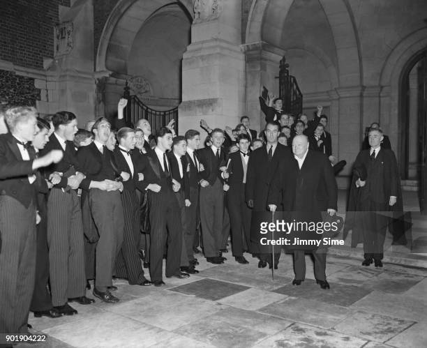 British Prime Minister Winston Churchill is cheered by the boys of Harrow School after a visit to his alma mater, 7th November 1952.