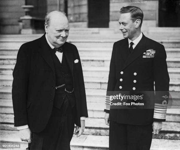 British Prime Minister Winston Churchill with King George VI in the grounds of Buckingham Palace, London, during World War II, circa 1942.