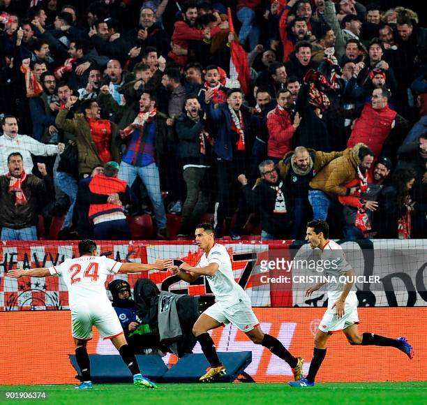 Sevilla's French forward Wissam Ben Yedder celebrates with Sevilla's forward Nolito and Sevilla's midfielder Jesus Navas after scoring a goal during...