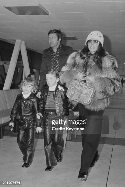 English actress Joan Collins leaves London Airport for Los Angeles with her partner Ron Kass and children Sacha and Tara, 30th December 1971. She is...