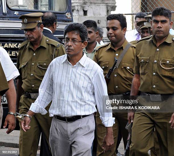 This photograph taken on November 5 shows Sri Lankan journalist J. S. Tissanayagam , flanked by prison guards, walking into the high court to hear...