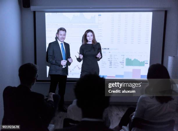 man and woman leading a business presentation - presenter stock pictures, royalty-free photos & images