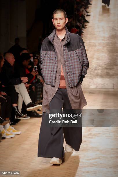 Model walks the runway at the Qasami show during London Fashion Week Men's January 2018 at 100 Sydney Street on January 6, 2018 in London, England.