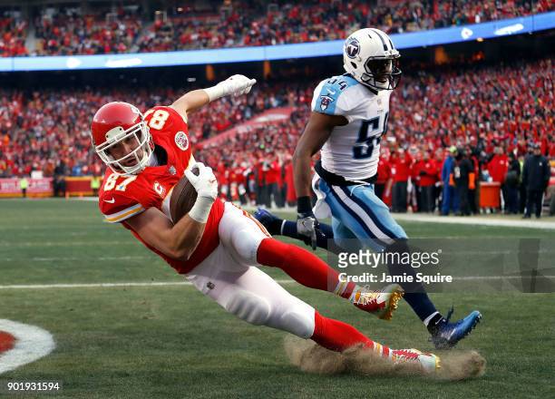 Tight end Travis Kelce of the Kansas City Chiefs catches a pass in the endzone for a touchdown as inside linebacker Avery Williamson of the Tennessee...