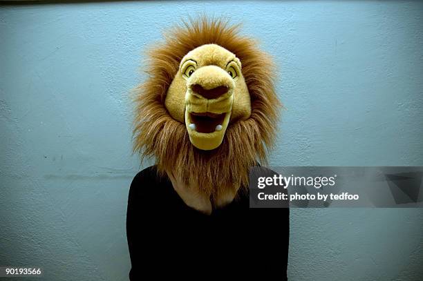 young woman with stuffed lion head - mask disguise stock-fotos und bilder