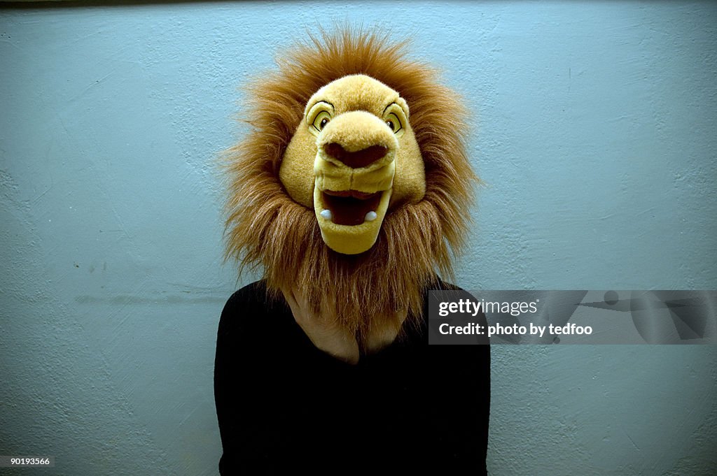 Young woman with stuffed lion head